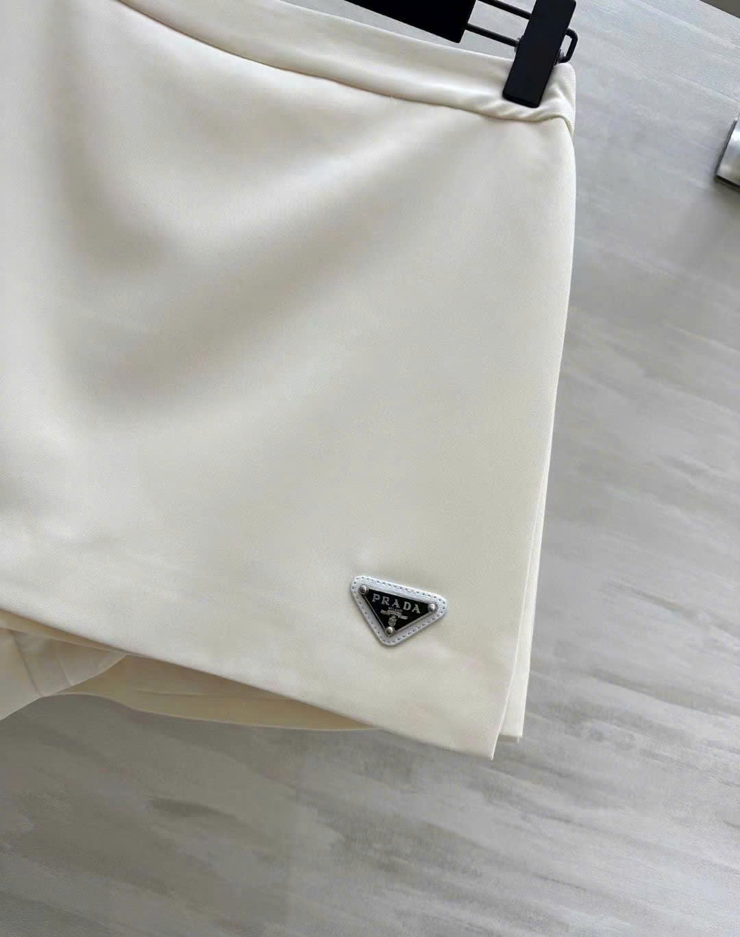 Váy ngắn vạt chéo kem và hồng Prada 10